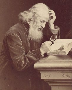 Man examining book with magnifying glass